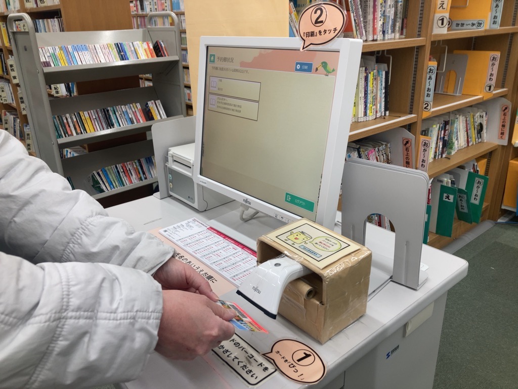 予約照会機にバーコードをかざす写真